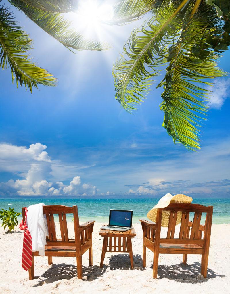 椅子笔记本电脑在沙滩上
