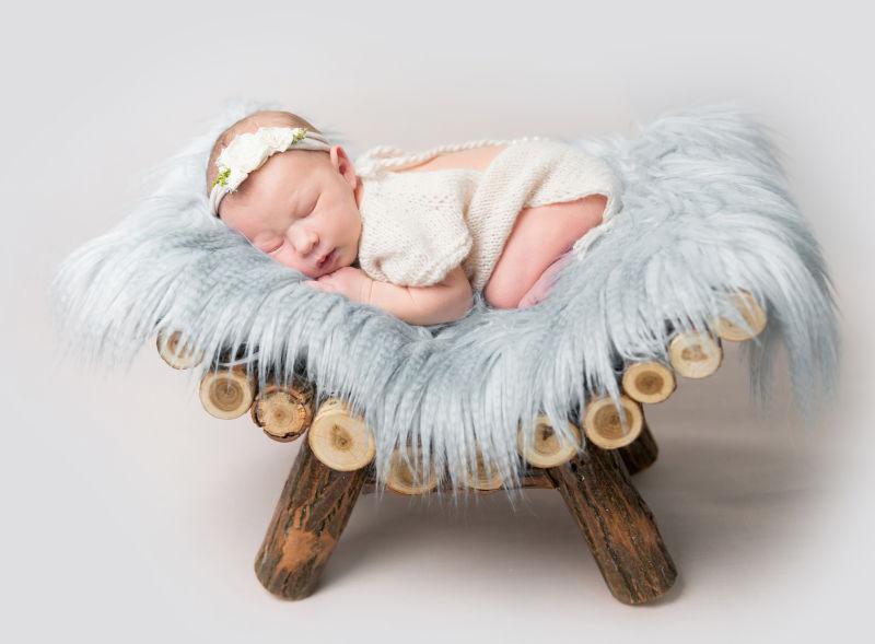 趴在灰色毛毯上睡觉的新生儿