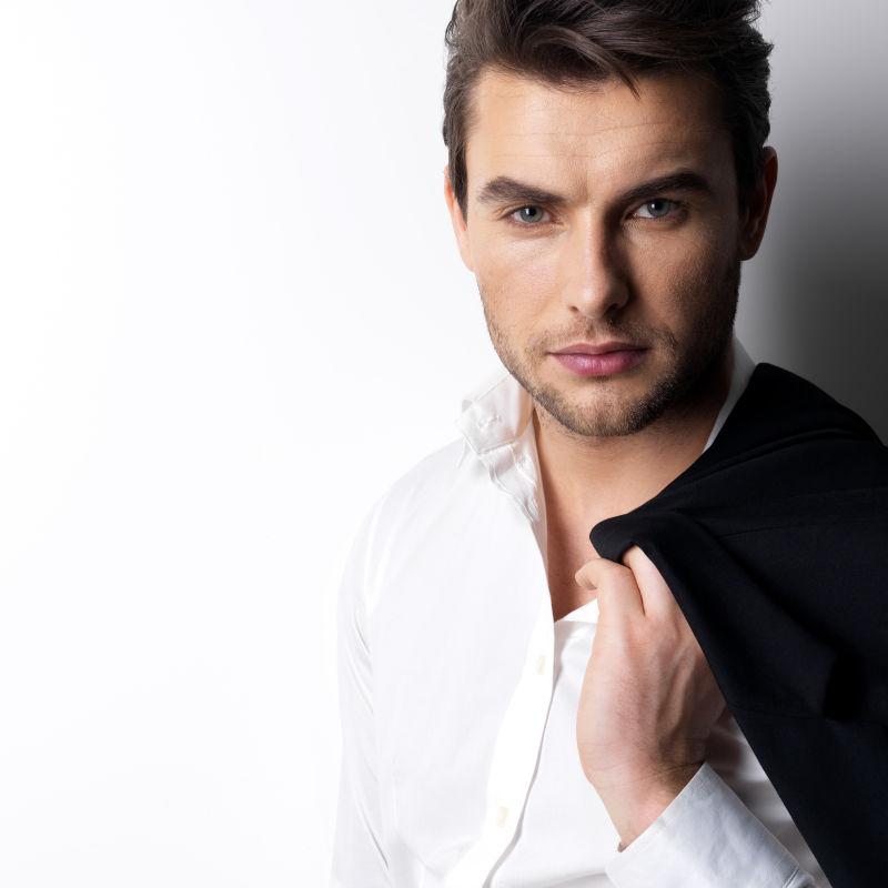 穿着白衬衫的时尚年轻人拿着黑色的夹