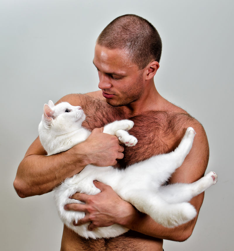 肌肉发达的男人抱着白猫