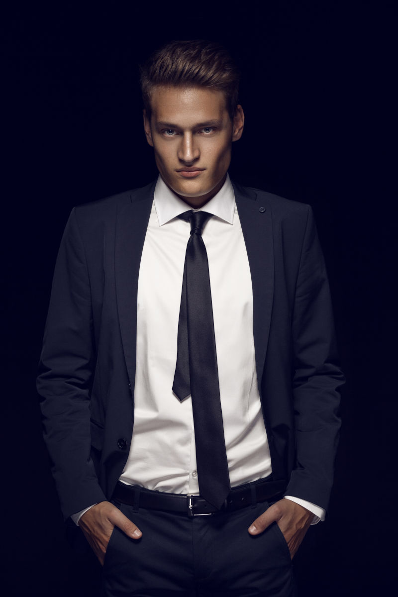 站在黑暗背景下的酷商人