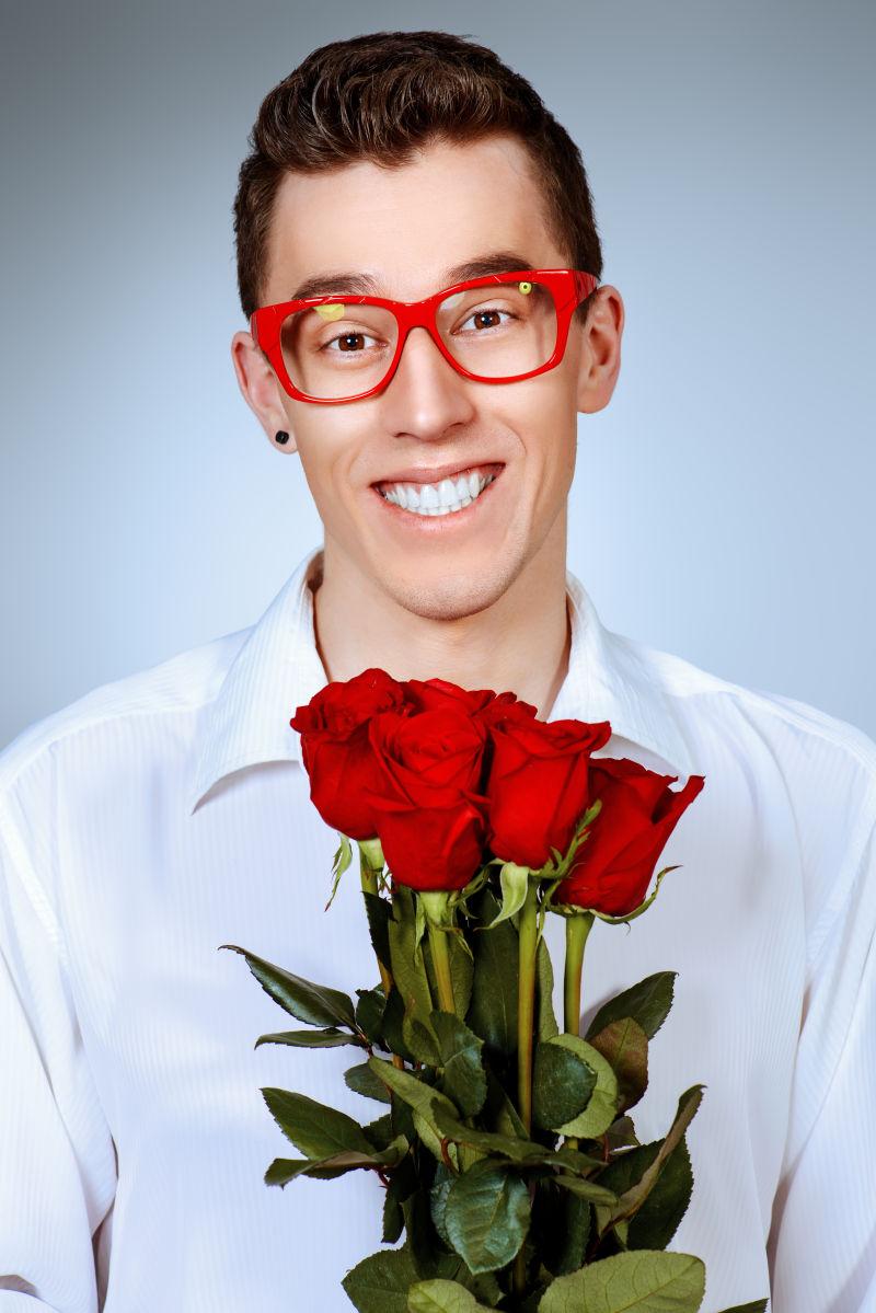 戴着眼镜的男人拿着花束图片 一个微笑的年轻人戴着一束红玫瑰的眼镜画像素材 高清图片 摄影照片 寻图免费打包下载