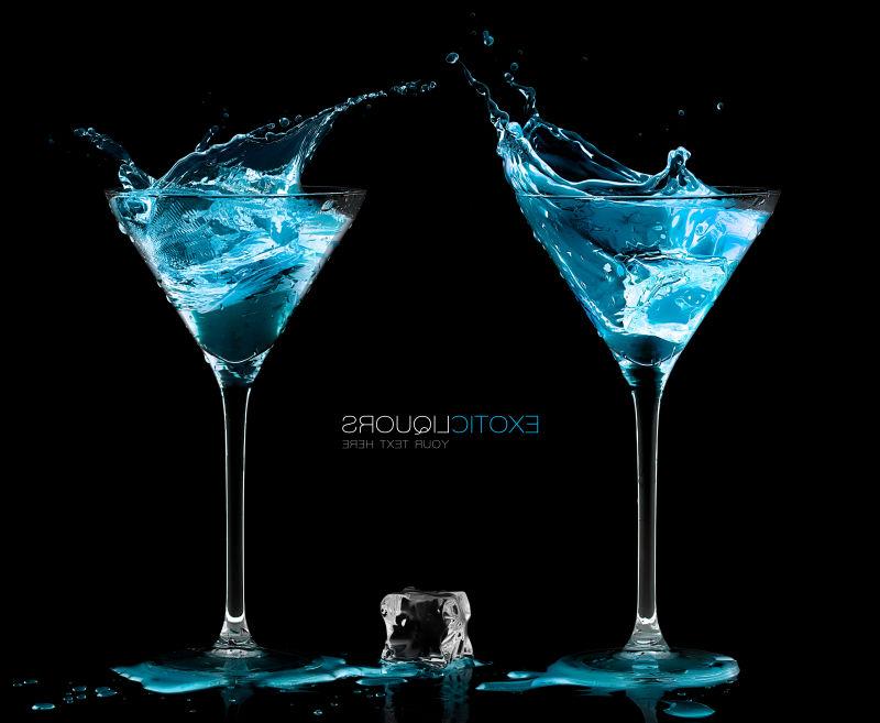 冰块在两杯鸡尾酒杯之间装满了蓝色酒精异味利口酒