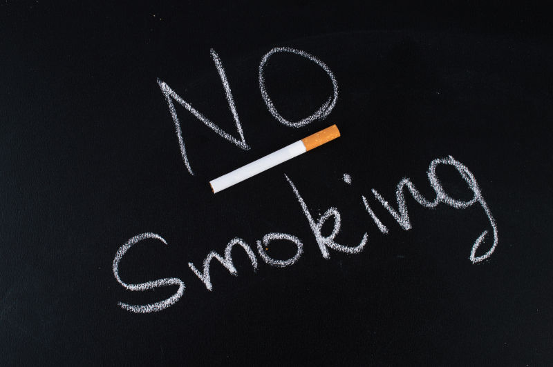 黑色背景下的香烟和不要吸烟提示