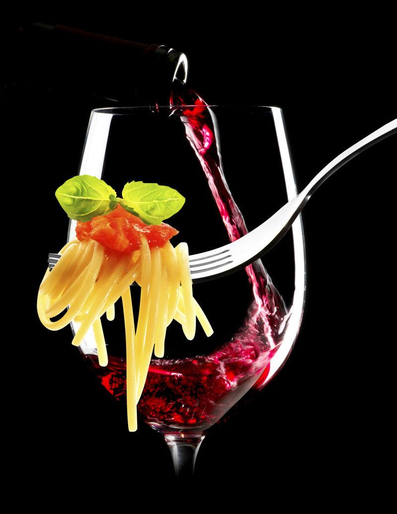 黑色背景下的红酒和意大利面条