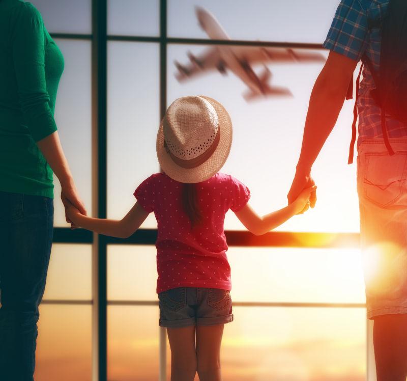 夕阳下机场候车室带着孩子的年轻夫妇