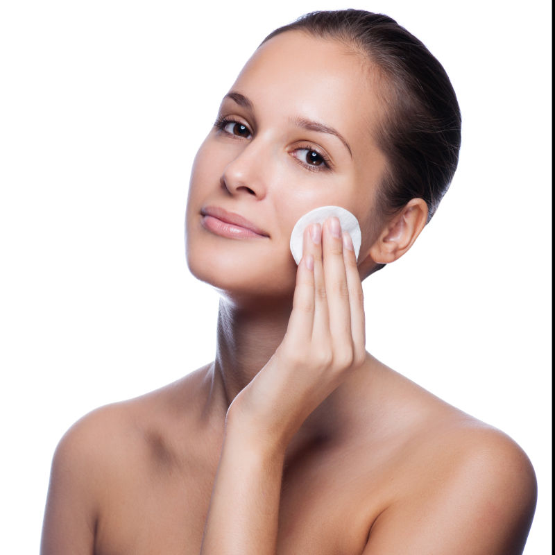 年轻的女子在脸上涂抹护肤品