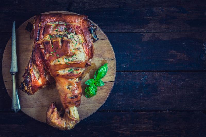 木制背景中的烤全猪腿