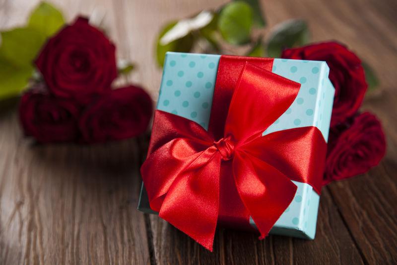 木桌上的情人节玫瑰和礼品盒