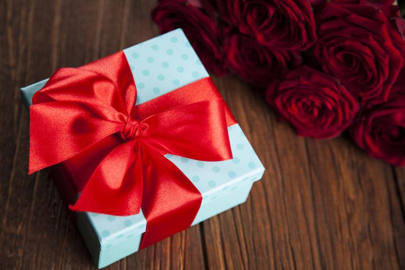 木桌背景上的情人节玫瑰与礼品盒