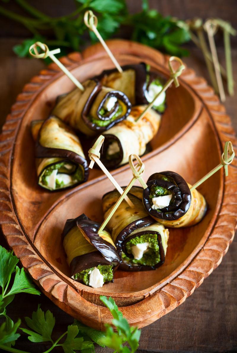 茄子用香草和羊肚菌卷在老式木板上