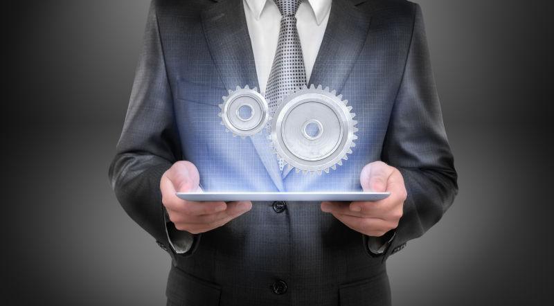 一个穿着西装的商人拿着一个发光的平板电脑