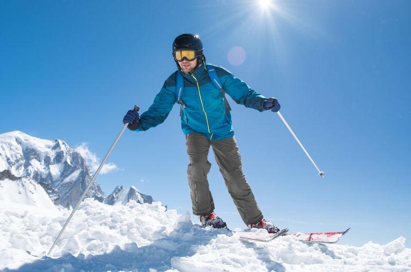 滑雪者在阳光充足的阿尔卑斯山坡上下坡