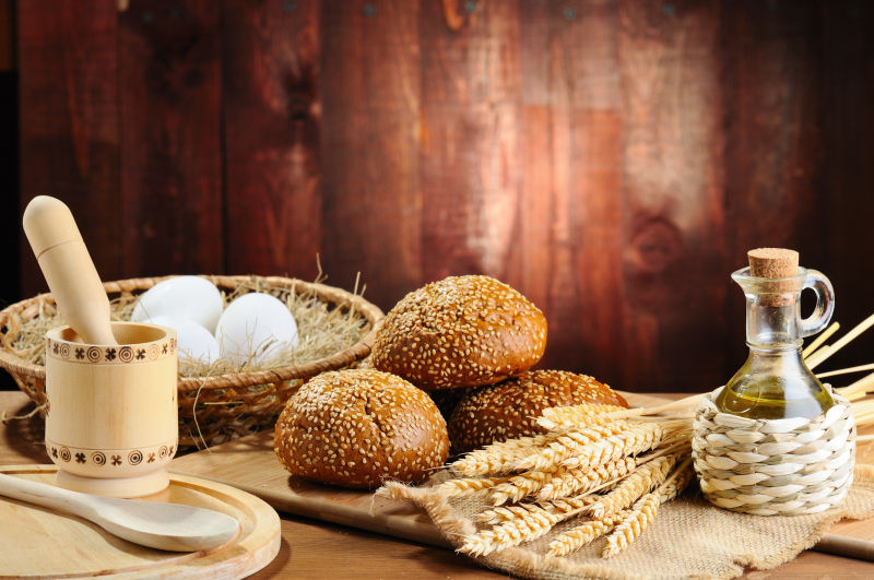 木桌上的小麦面包与鸡蛋麦穗