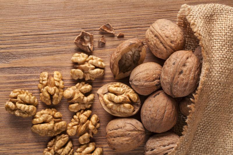 木桌上的剥开的核桃仁和全核桃