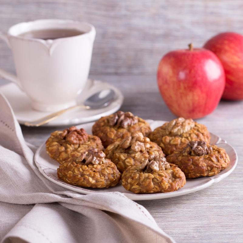 木制背景中的坚果饼干苹果核桃和咖啡