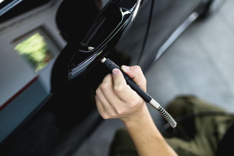 工人用轨道抛光机修理汽车门把