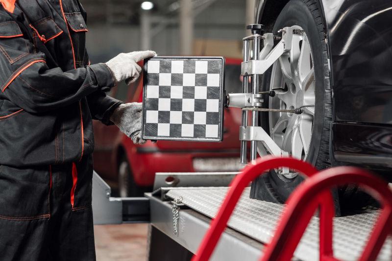 汽车修理工使用车轮定位装置修理汽车