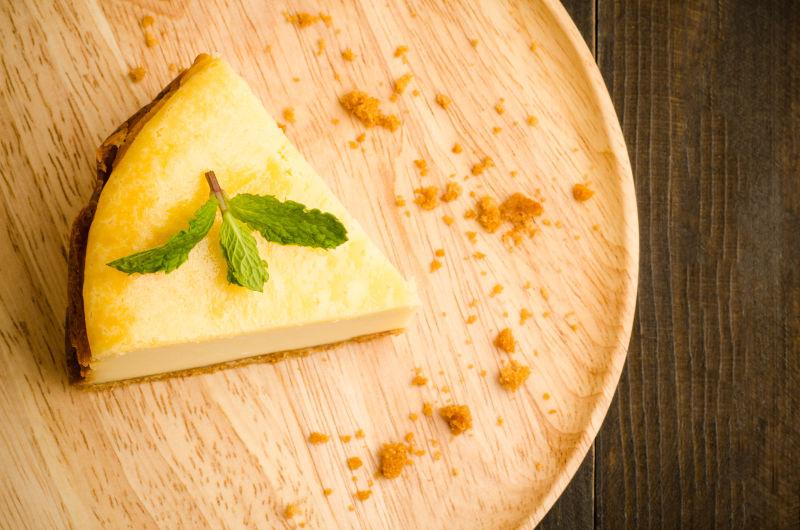 木制背景上木板上的芝士蛋糕