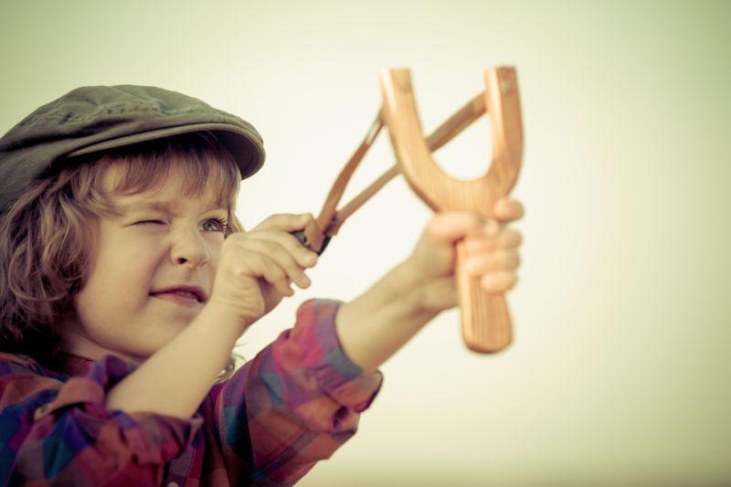 孩子拿着弹弓手对着远方