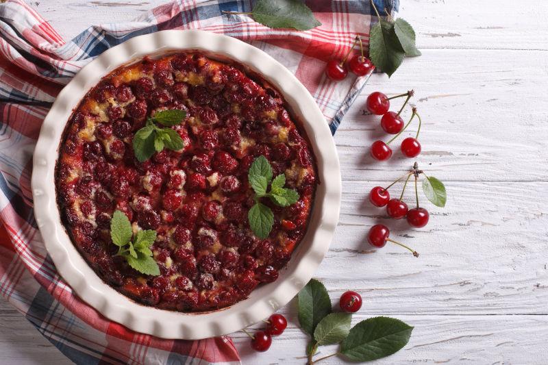 白色木桌上格子餐布上的樱桃水果馅饼