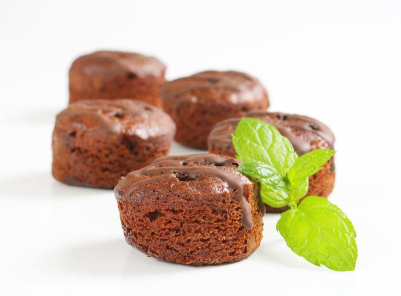 白色背景上的迷你巧克力蛋糕和薄荷叶