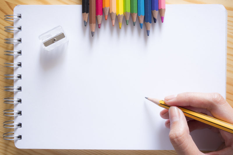 拿着黄色铅笔绘画的人