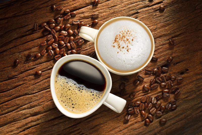 旧木桌上的两杯咖啡和棕色的咖啡豆