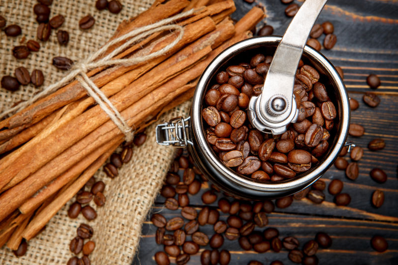 木桌上的咖啡豆与老式打磨机