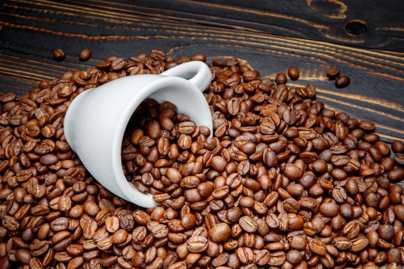 木桌上很多的咖啡豆和杯子