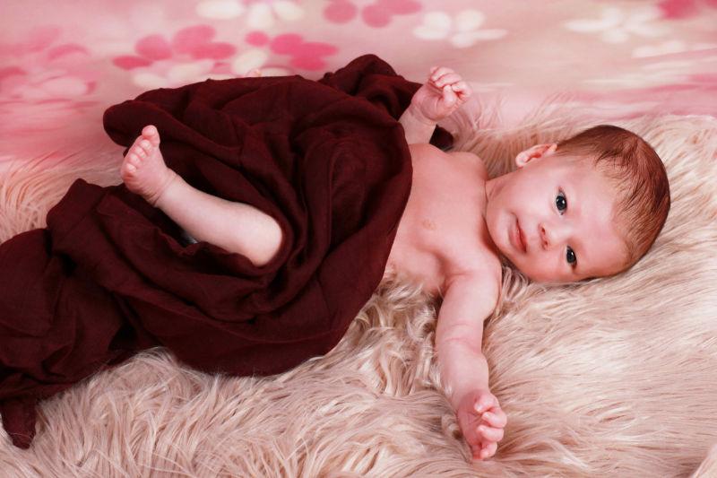 新生婴儿躺在假皮毛上