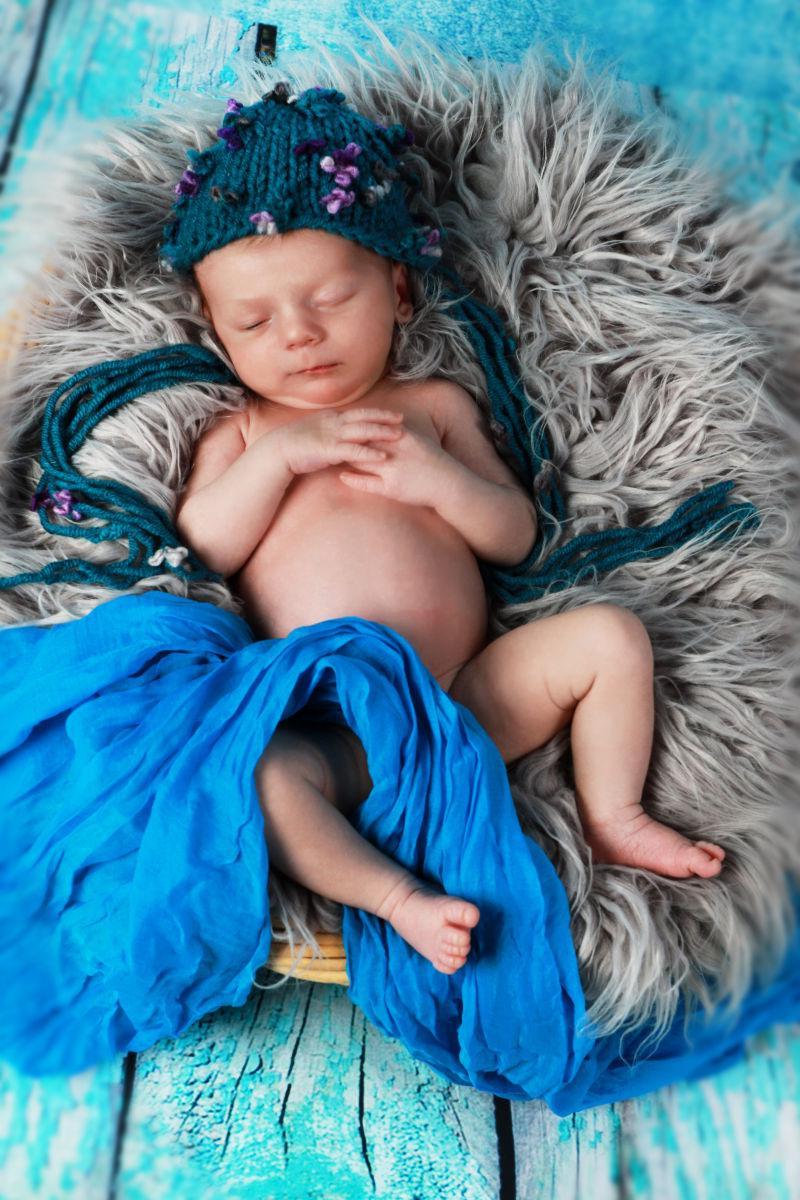 躺在毛皮篮子里的新生婴儿