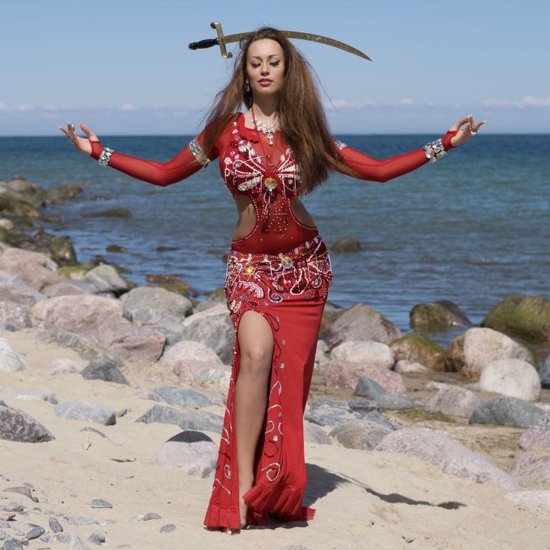 海滩上穿着鲜艳服装的肚皮舞者