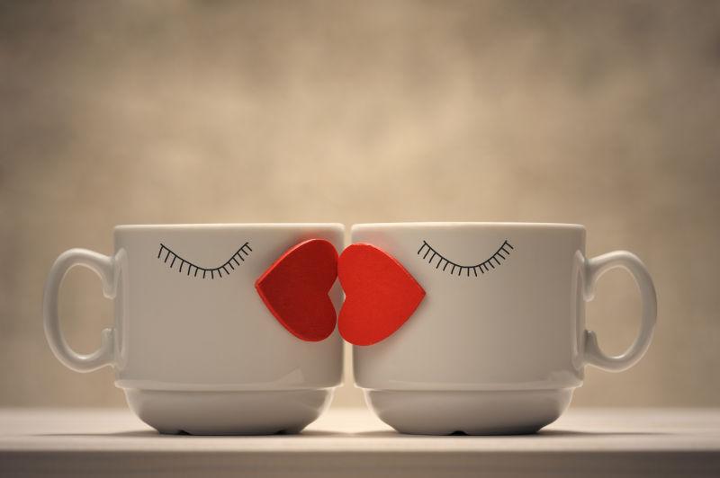 桌子上的两个红心咖啡杯亲吻唇