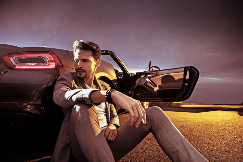 坐在车旁的英俊商人