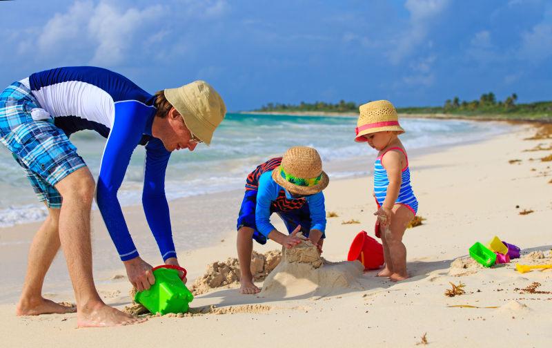 沙滩上玩耍的父子三人
