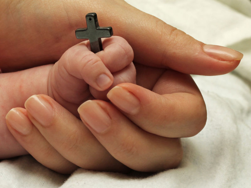 宝宝的手抓着十字架