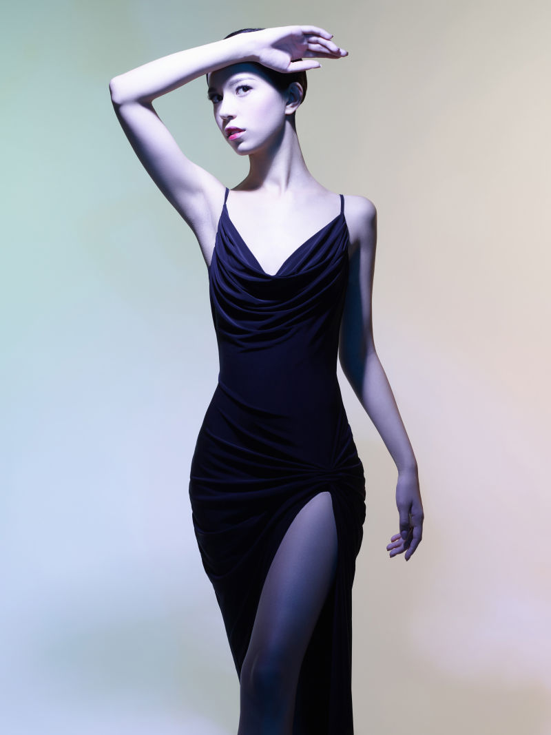 灰色背景上穿黑色礼服的美女模特