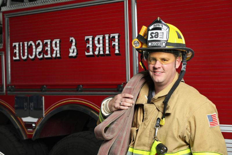 消防车前带着头盔的消防员