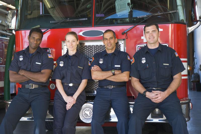 坐在消防车前的四个消防员