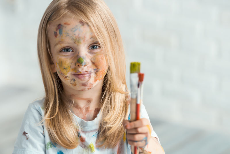 脸上沾满颜料的金发女孩