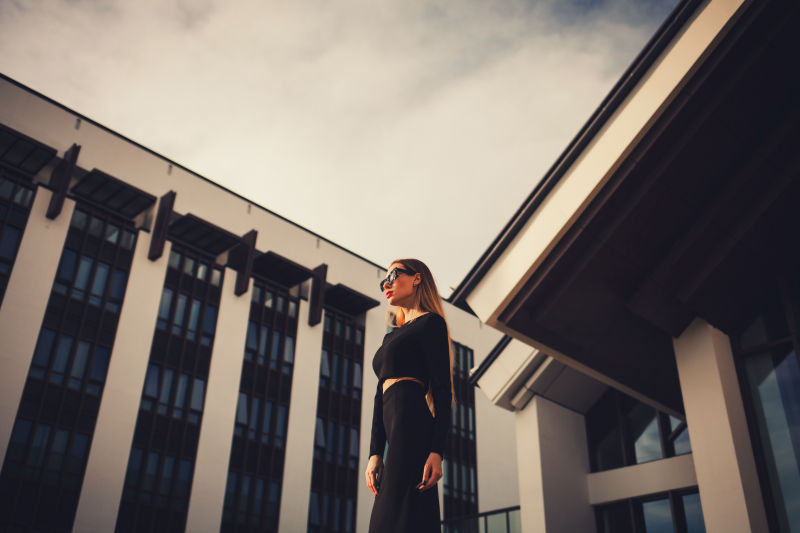 站在现代建筑旁边的时尚美女