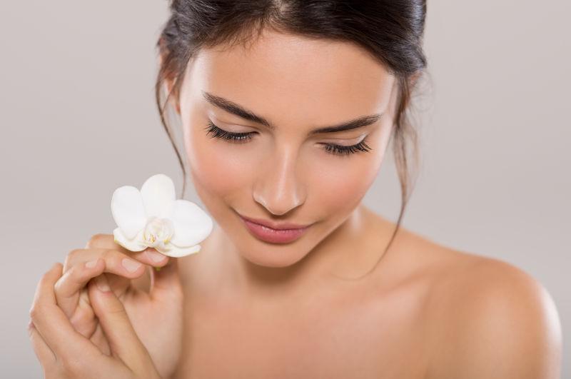 性感的年轻美女手拿白色小花