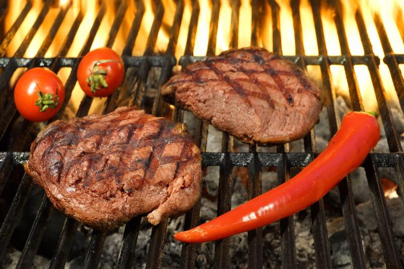 的热火焰烧烤烤架上的番茄和辣椒