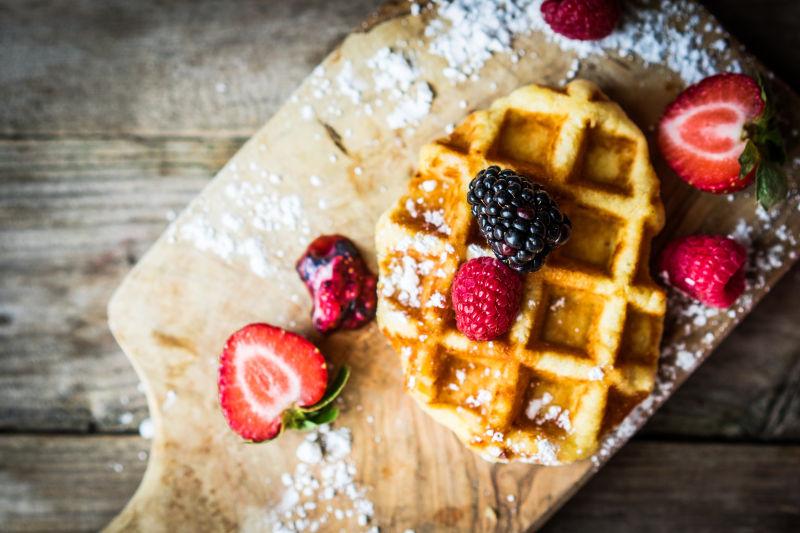 木制背景中的新鲜浆果比利时华夫饼