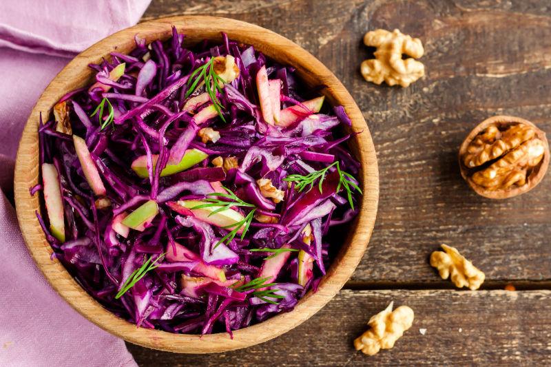 旧木板上的紫甘蓝沙拉和核桃