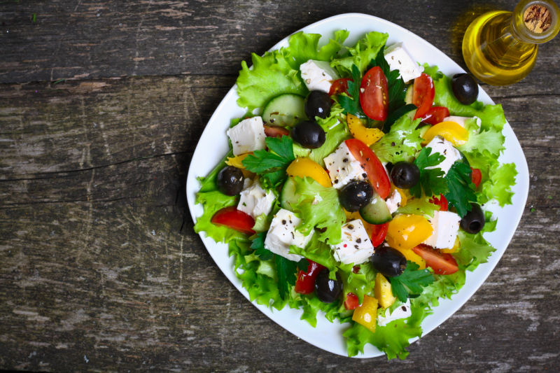旧木桌上的新鲜希腊沙拉