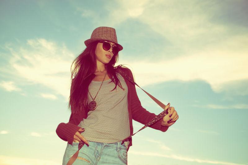 戴着帽子和太阳镜的年轻女子