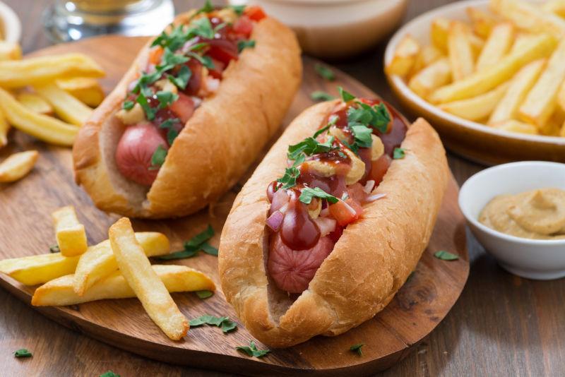 西红柿和木板上的洋葱热狗