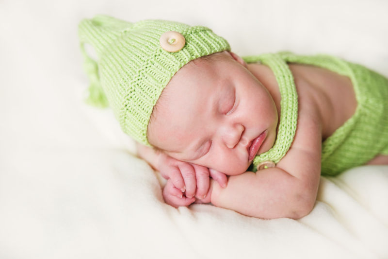 可爱的婴儿趴在白色的垫子上睡觉